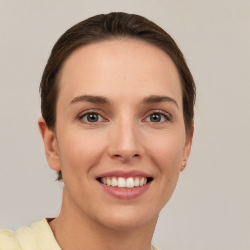 Joyful white young-adult female with short  brown hair and grey eyes