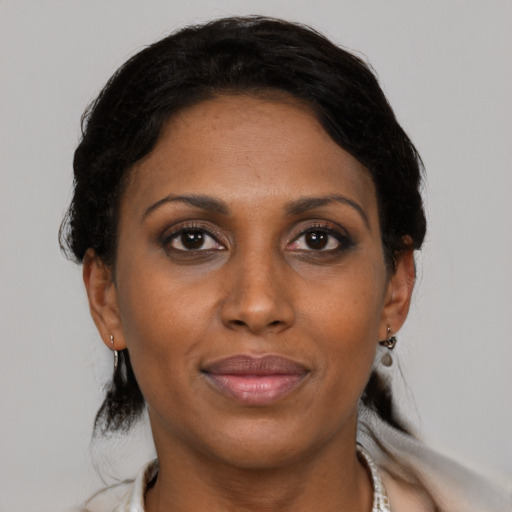 Joyful black adult female with medium  brown hair and brown eyes