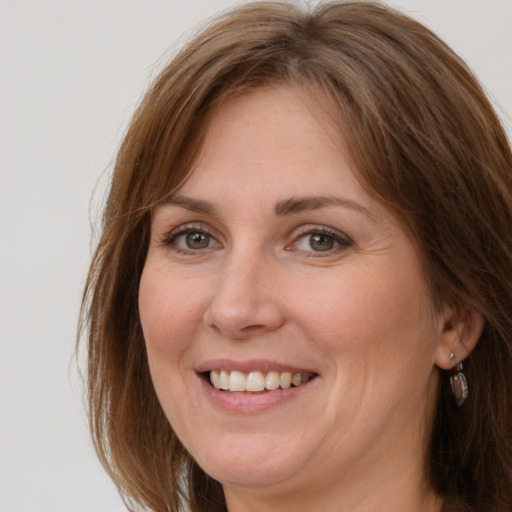 Joyful white adult female with long  brown hair and grey eyes