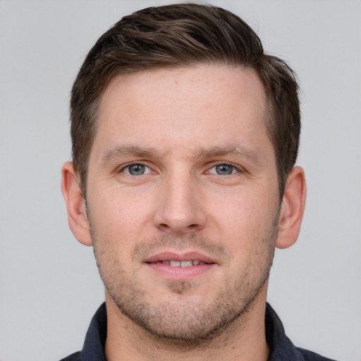 Joyful white young-adult male with short  brown hair and grey eyes