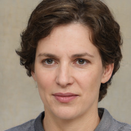 Joyful white adult female with medium  brown hair and grey eyes