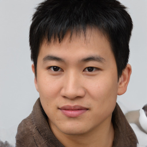 Joyful asian young-adult male with short  brown hair and brown eyes