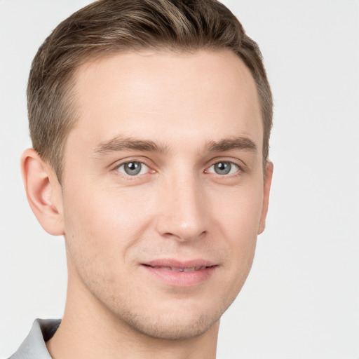 Joyful white young-adult male with short  brown hair and grey eyes