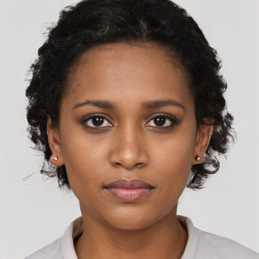 Joyful black young-adult female with short  black hair and brown eyes