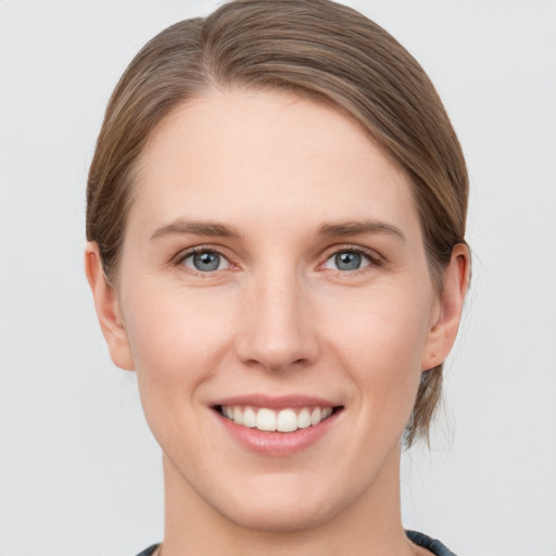 Joyful white young-adult female with medium  brown hair and grey eyes