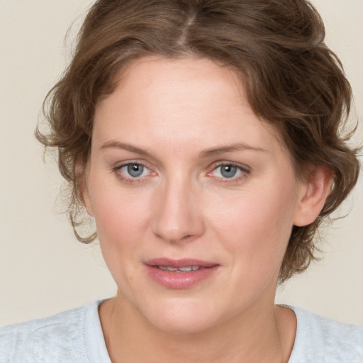 Joyful white young-adult female with medium  brown hair and blue eyes