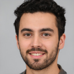 Joyful white young-adult male with short  black hair and brown eyes