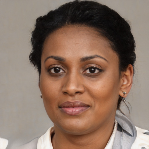 Joyful black young-adult female with short  black hair and brown eyes