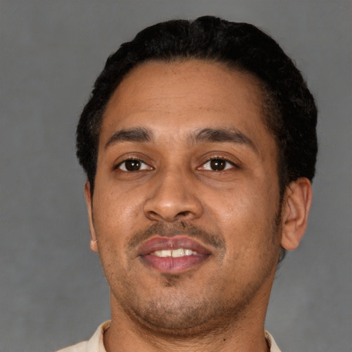 Joyful latino adult male with short  black hair and brown eyes