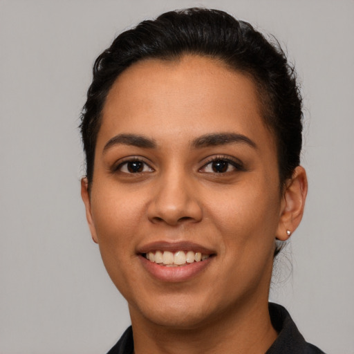 Joyful latino young-adult female with short  black hair and brown eyes