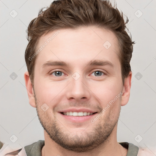 Joyful white young-adult male with short  brown hair and grey eyes