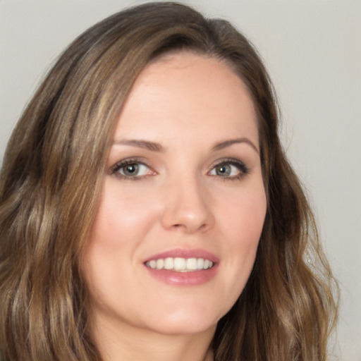 Joyful white young-adult female with long  brown hair and brown eyes