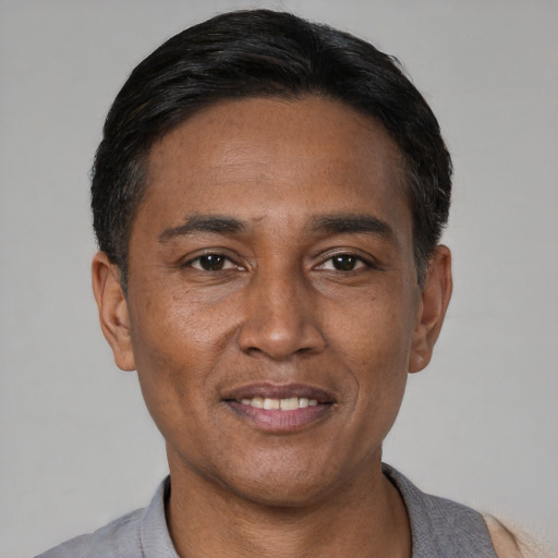 Joyful latino adult male with short  black hair and brown eyes