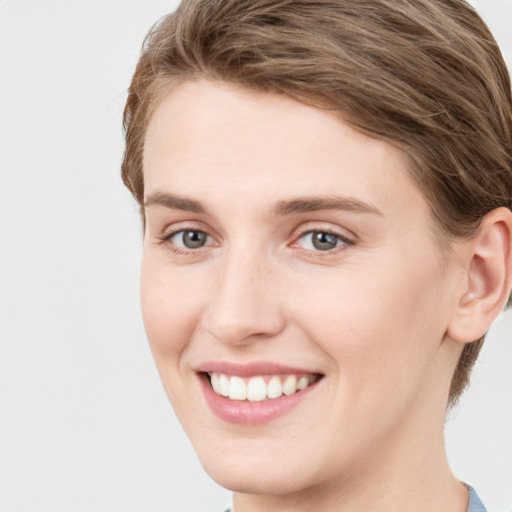 Joyful white young-adult female with short  brown hair and grey eyes