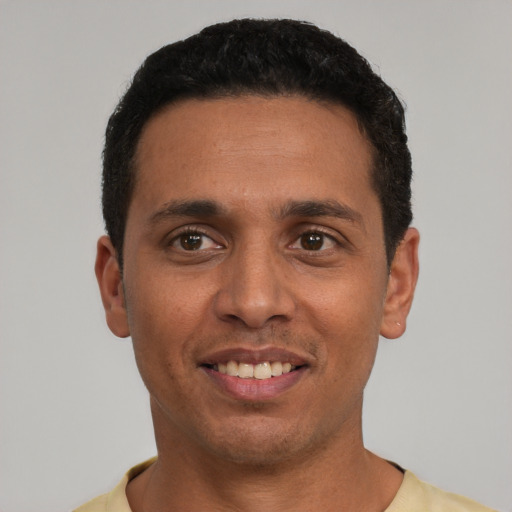 Joyful latino young-adult male with short  black hair and brown eyes