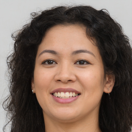Joyful asian young-adult female with long  brown hair and brown eyes