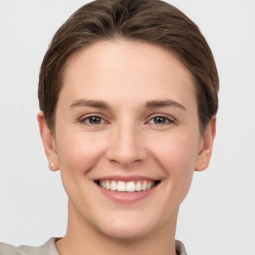 Joyful white young-adult female with short  brown hair and grey eyes