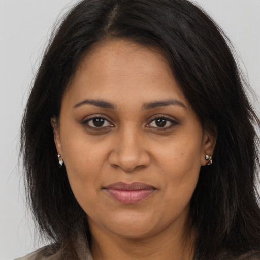 Joyful black young-adult female with long  brown hair and brown eyes