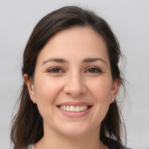 Joyful white young-adult female with long  brown hair and brown eyes