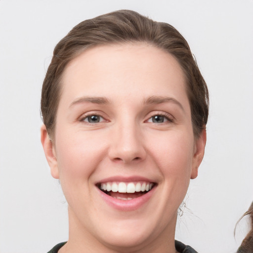 Joyful white young-adult female with medium  brown hair and grey eyes