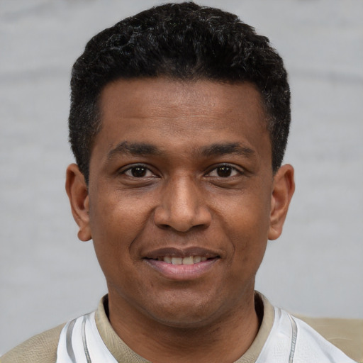 Joyful latino young-adult male with short  black hair and brown eyes