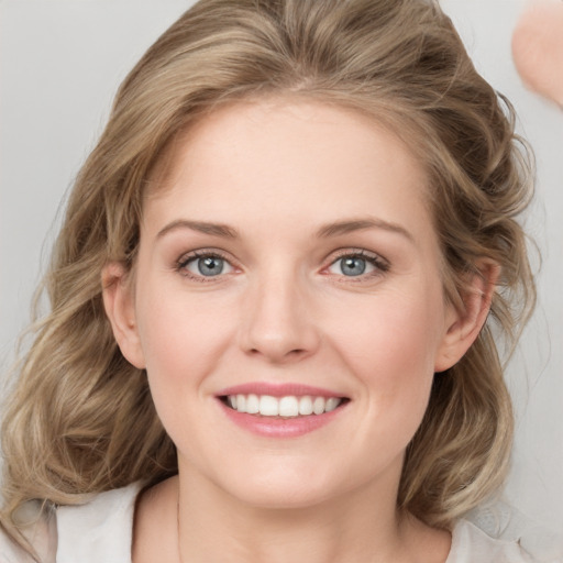 Joyful white young-adult female with medium  brown hair and blue eyes