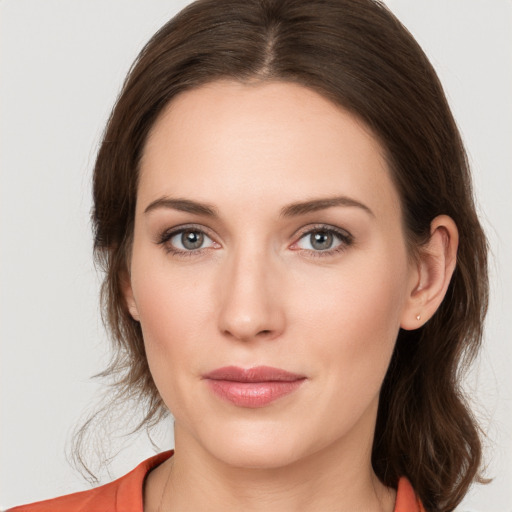 Joyful white young-adult female with medium  brown hair and grey eyes