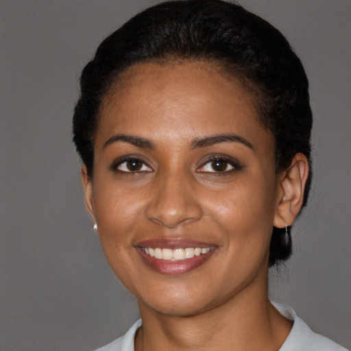 Joyful black young-adult female with short  black hair and brown eyes