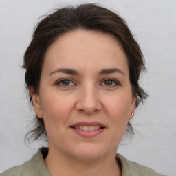 Joyful white adult female with medium  brown hair and brown eyes