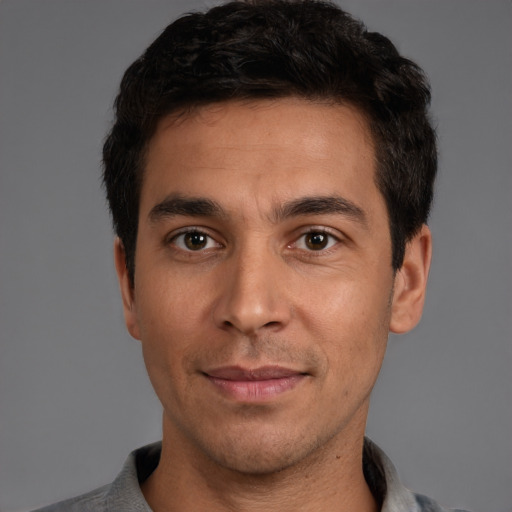 Joyful white young-adult male with short  black hair and brown eyes