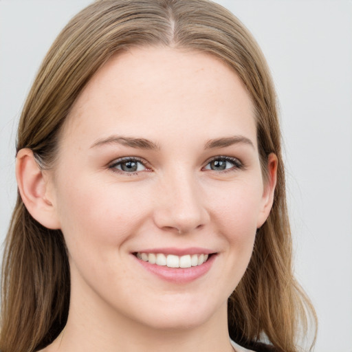 Joyful white young-adult female with long  brown hair and grey eyes