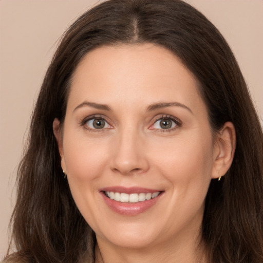 Joyful white adult female with long  brown hair and brown eyes