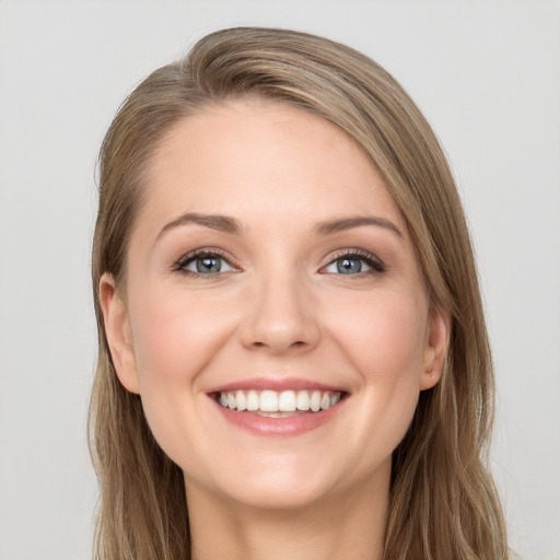 Joyful white young-adult female with long  brown hair and grey eyes