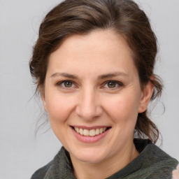 Joyful white young-adult female with medium  brown hair and grey eyes