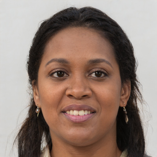 Joyful black young-adult female with long  brown hair and brown eyes