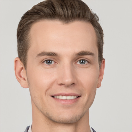 Joyful white young-adult male with short  brown hair and grey eyes