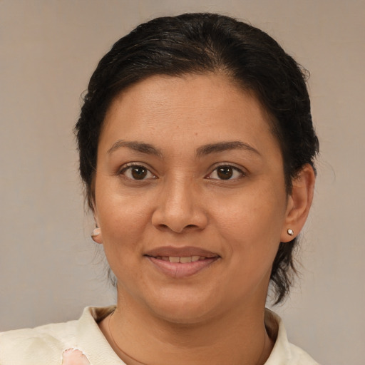 Joyful latino adult female with medium  brown hair and brown eyes