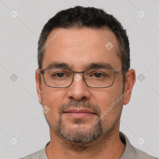 Joyful white adult male with short  black hair and brown eyes