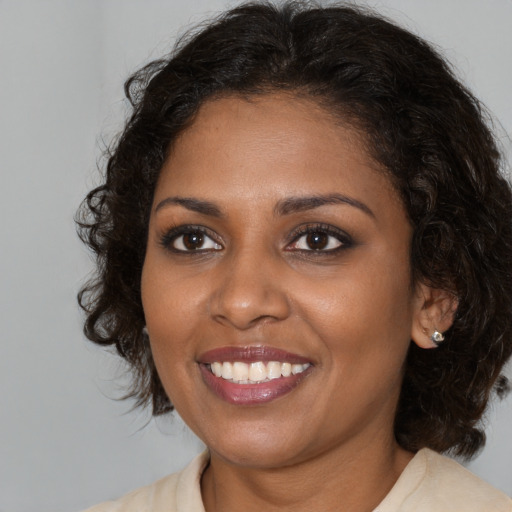 Joyful black young-adult female with medium  brown hair and brown eyes