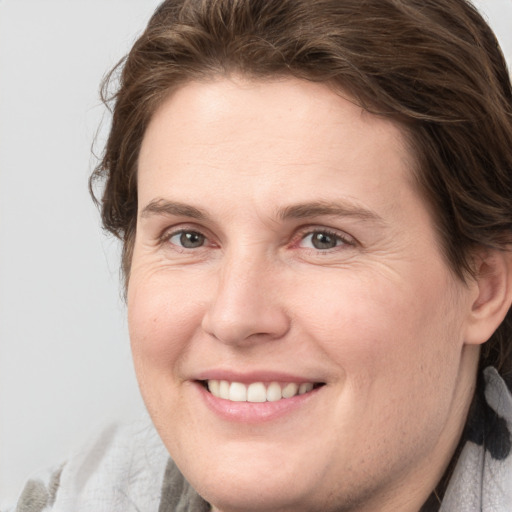 Joyful white adult female with medium  brown hair and grey eyes