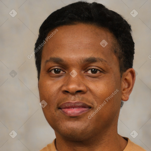 Joyful black young-adult male with short  brown hair and brown eyes