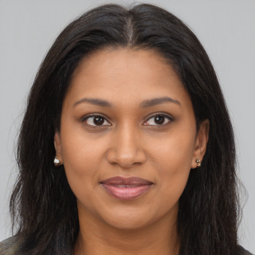 Joyful black young-adult female with long  brown hair and brown eyes