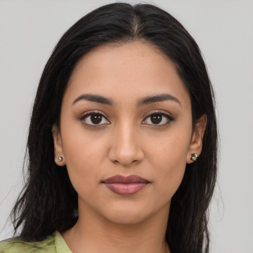 Joyful latino young-adult female with long  brown hair and brown eyes