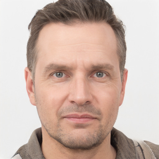 Joyful white adult male with short  brown hair and grey eyes