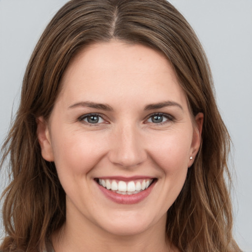 Joyful white young-adult female with long  brown hair and brown eyes