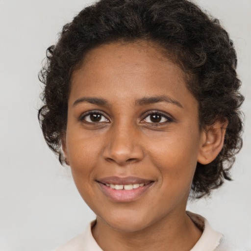 Joyful black young-adult female with short  brown hair and brown eyes