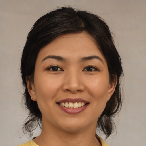Joyful asian young-adult female with medium  brown hair and brown eyes