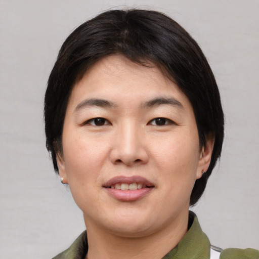 Joyful asian young-adult female with medium  brown hair and brown eyes