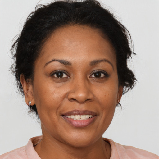 Joyful black adult female with medium  brown hair and brown eyes