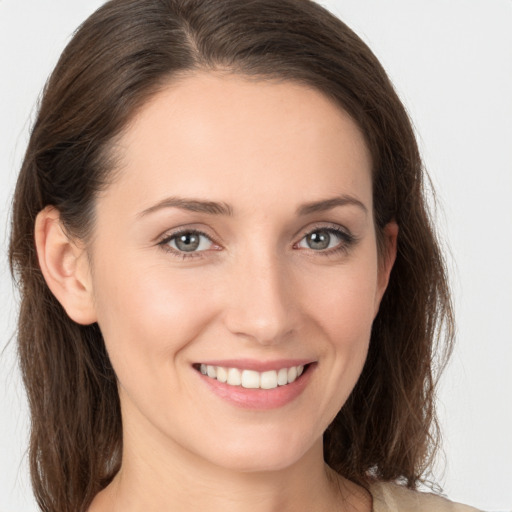 Joyful white young-adult female with medium  brown hair and grey eyes